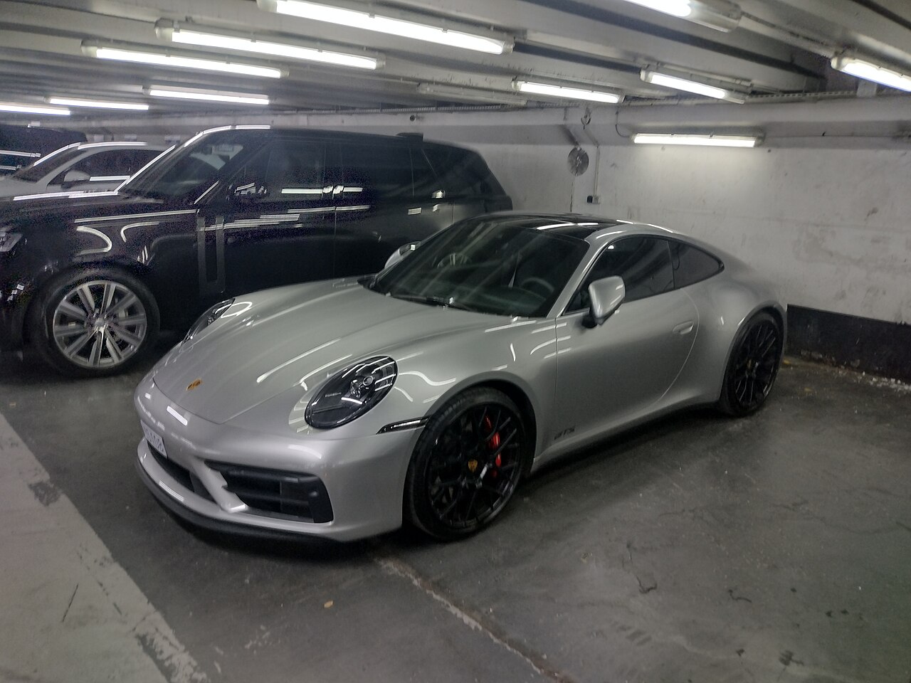 Silver Porsche 911 type 992 photographed in a parking garage